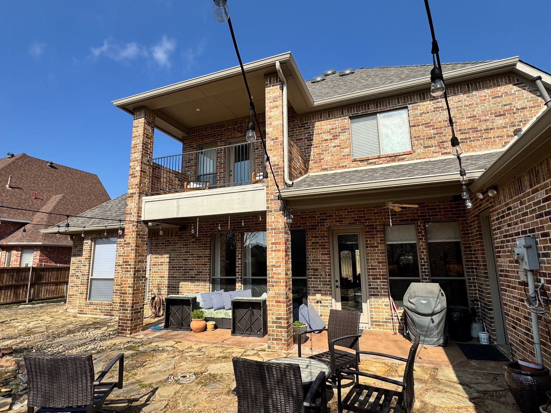 A large brick house with a patio area in front of it.