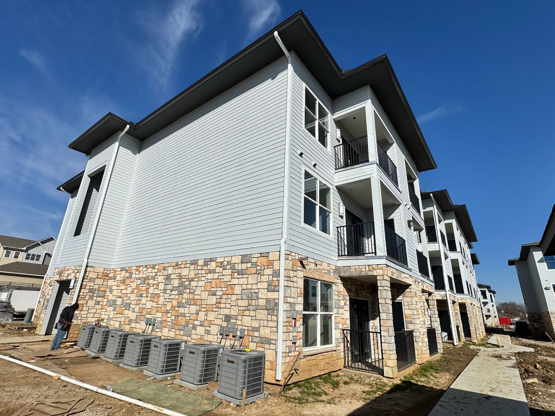 A large apartment building with a lot of windows is under construction.