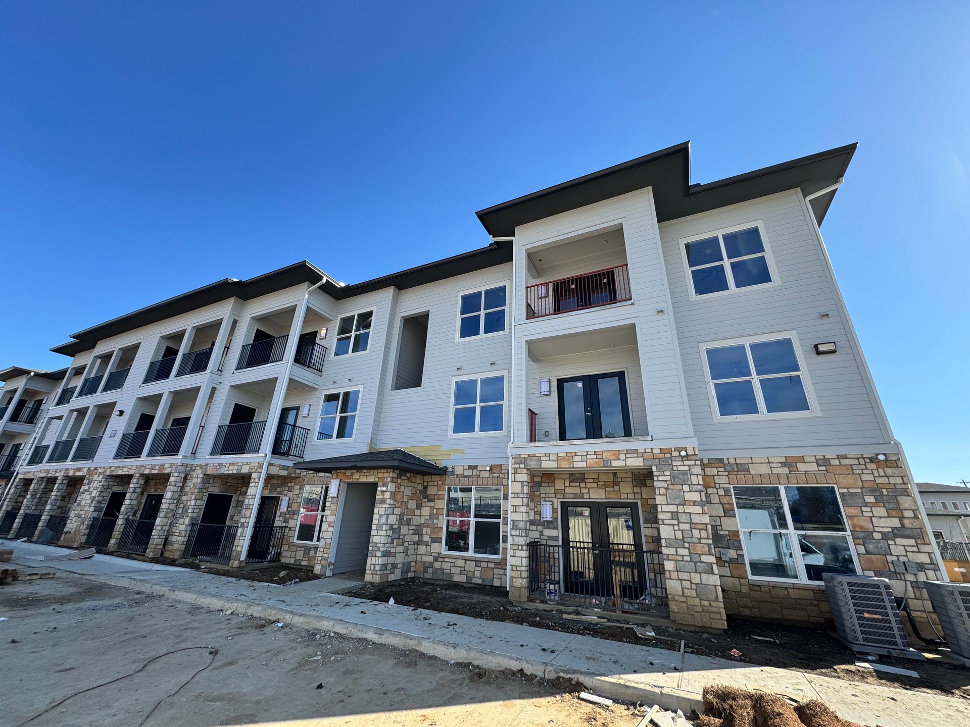 A large apartment building under construction with a blue sky in the background.