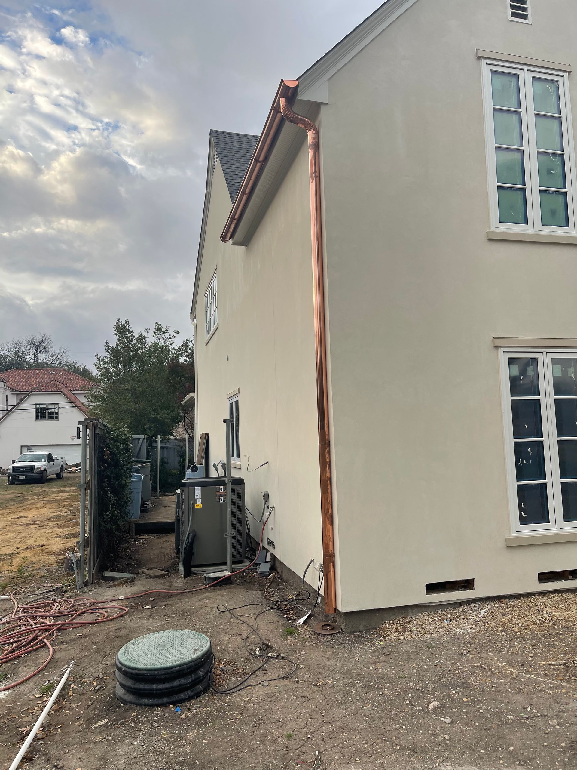 A white house with a copper pipe on the side