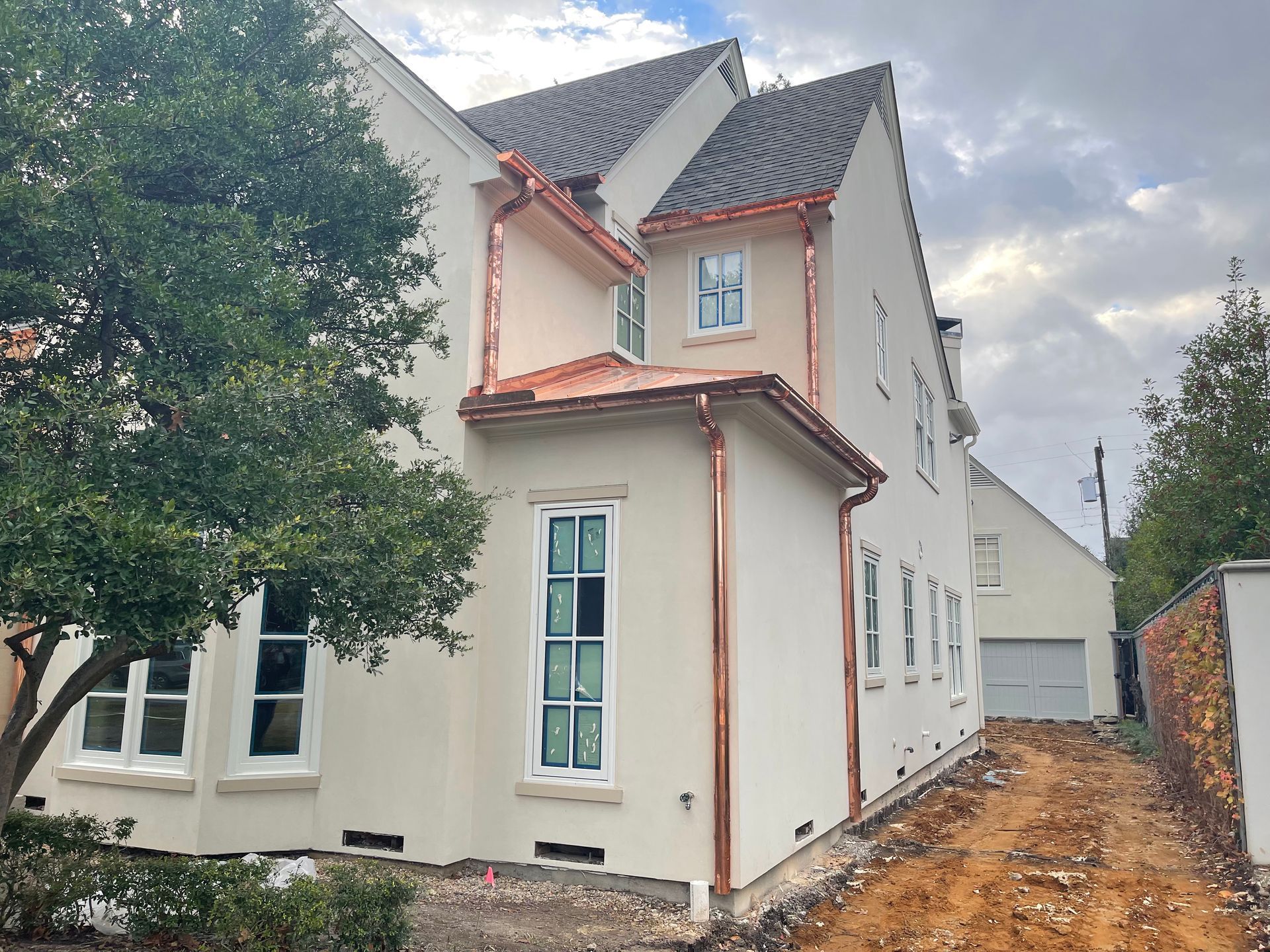 A white house with copper gutters and a copper roof