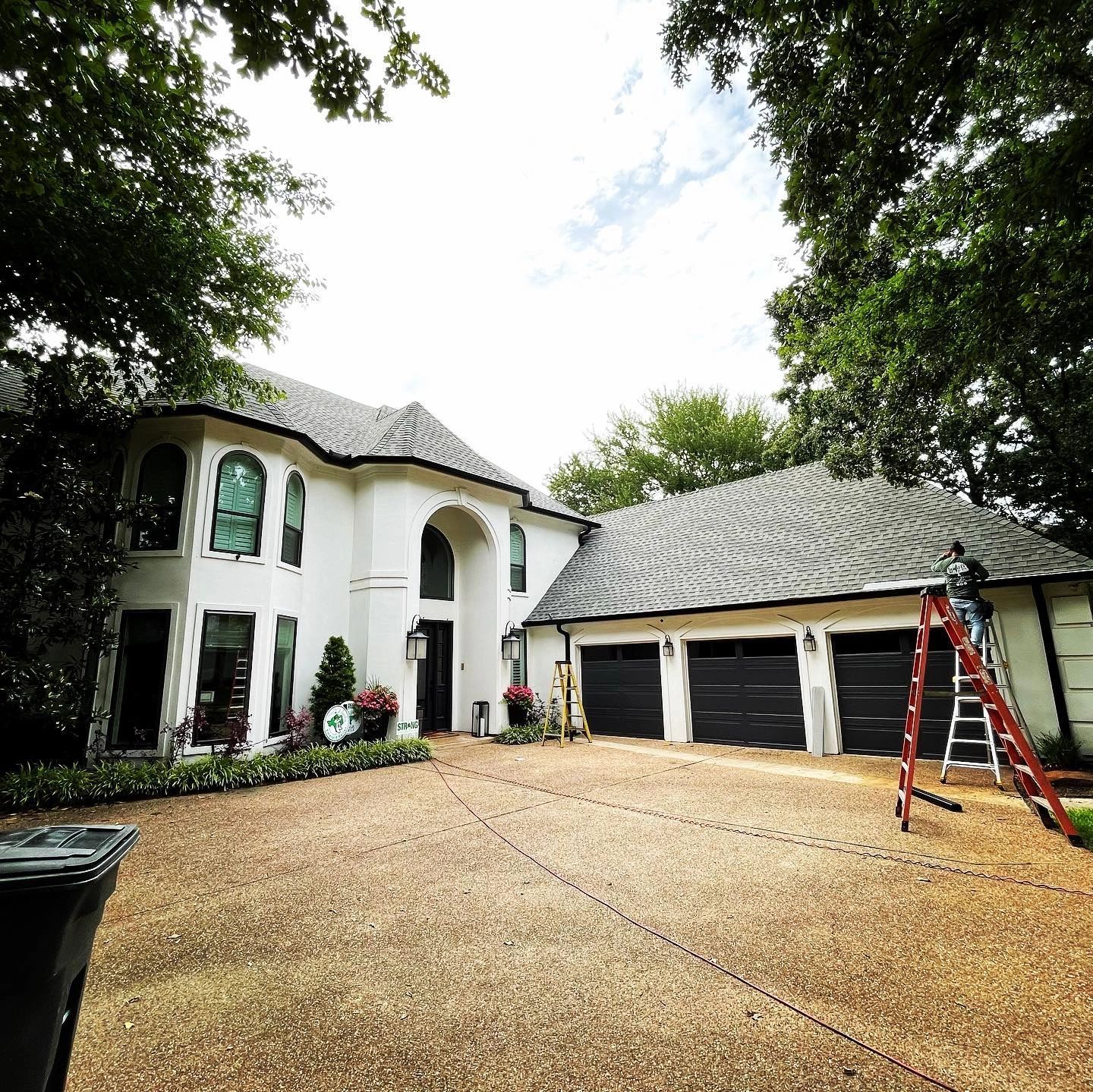 A large white house with a ladder in front of it.