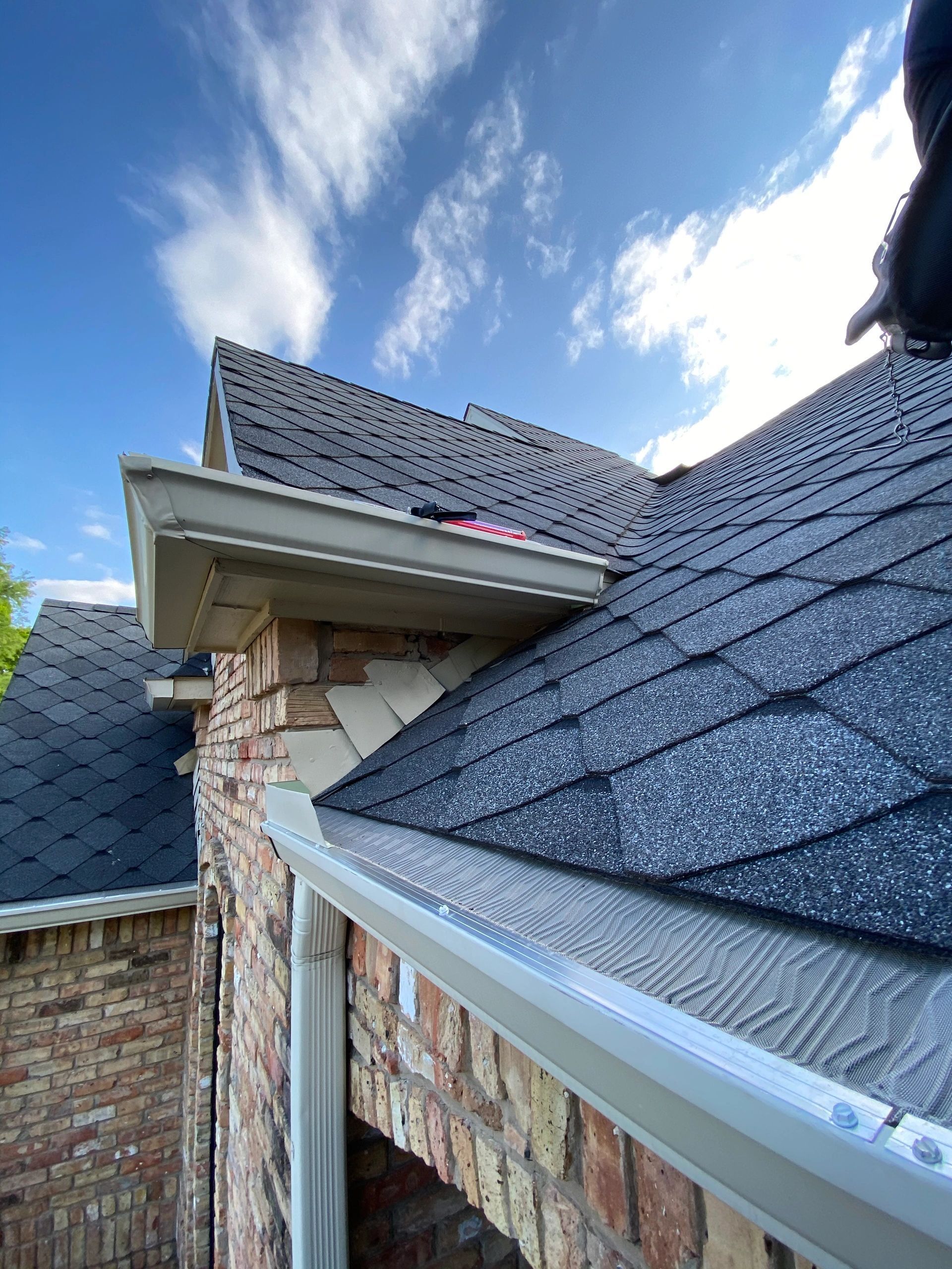 A man is working on the roof of a house.