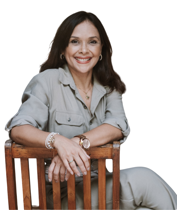 Una mujer está sentada en una silla de madera y sonriendo.