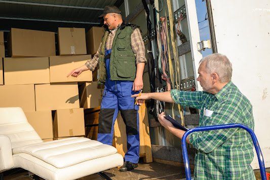 Two men are loading boxes into a truck.