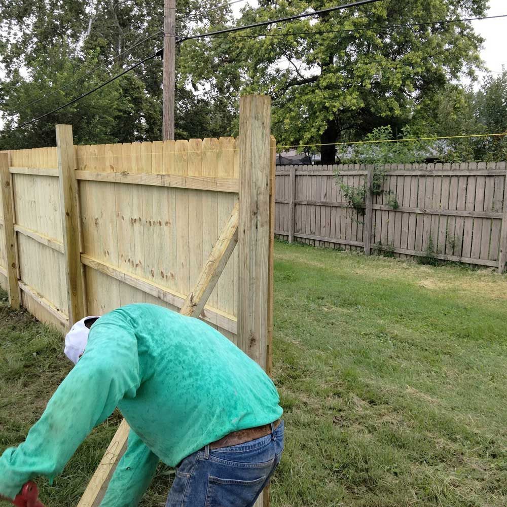 Man Fixing the Fence — Caseyville, IL — Two Brothers Tree Service and Landscape
