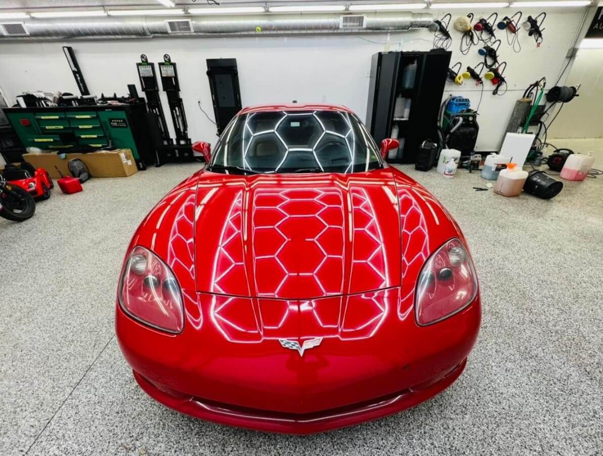 A red sports car is parked in a garage
