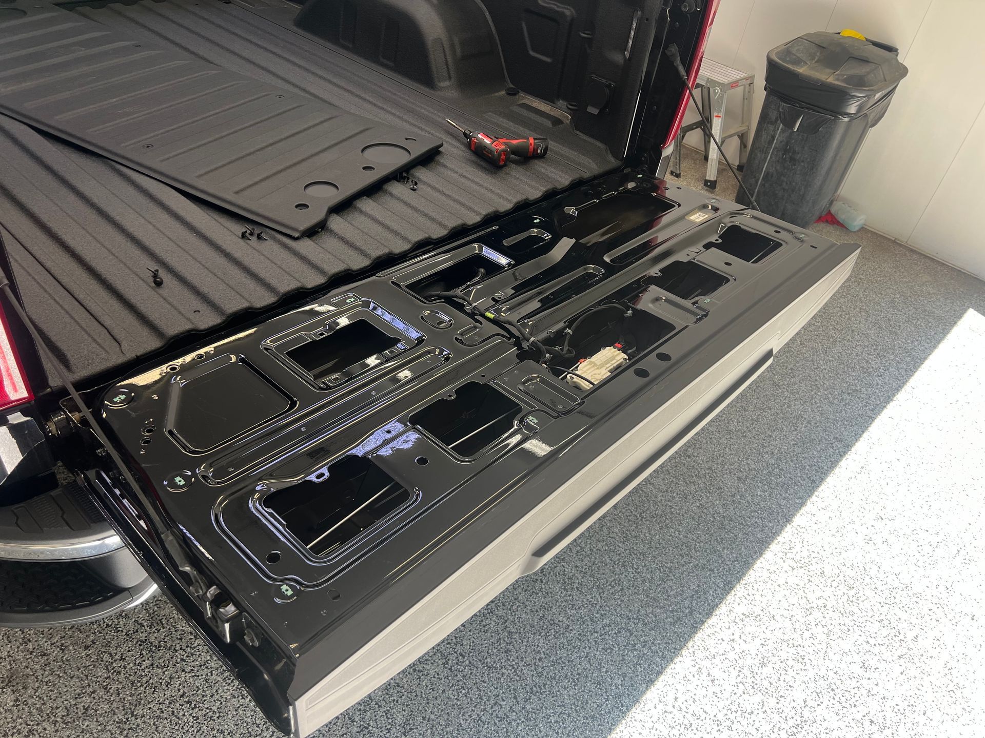 The back of a truck is being remodeled in a garage.