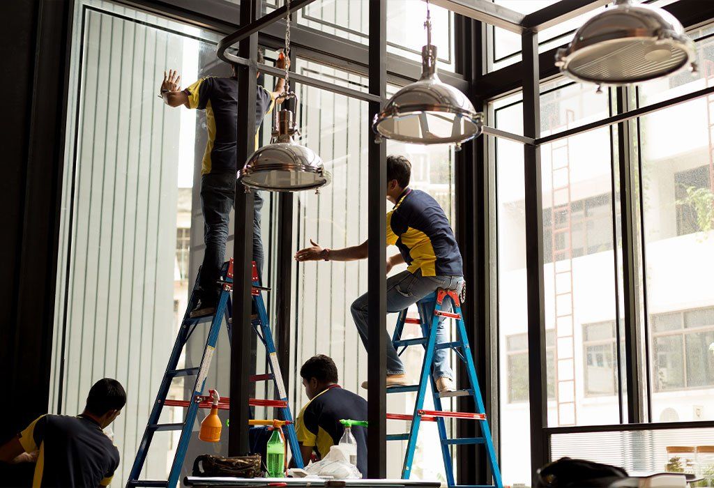 A group of men are cleaning a window in a building.