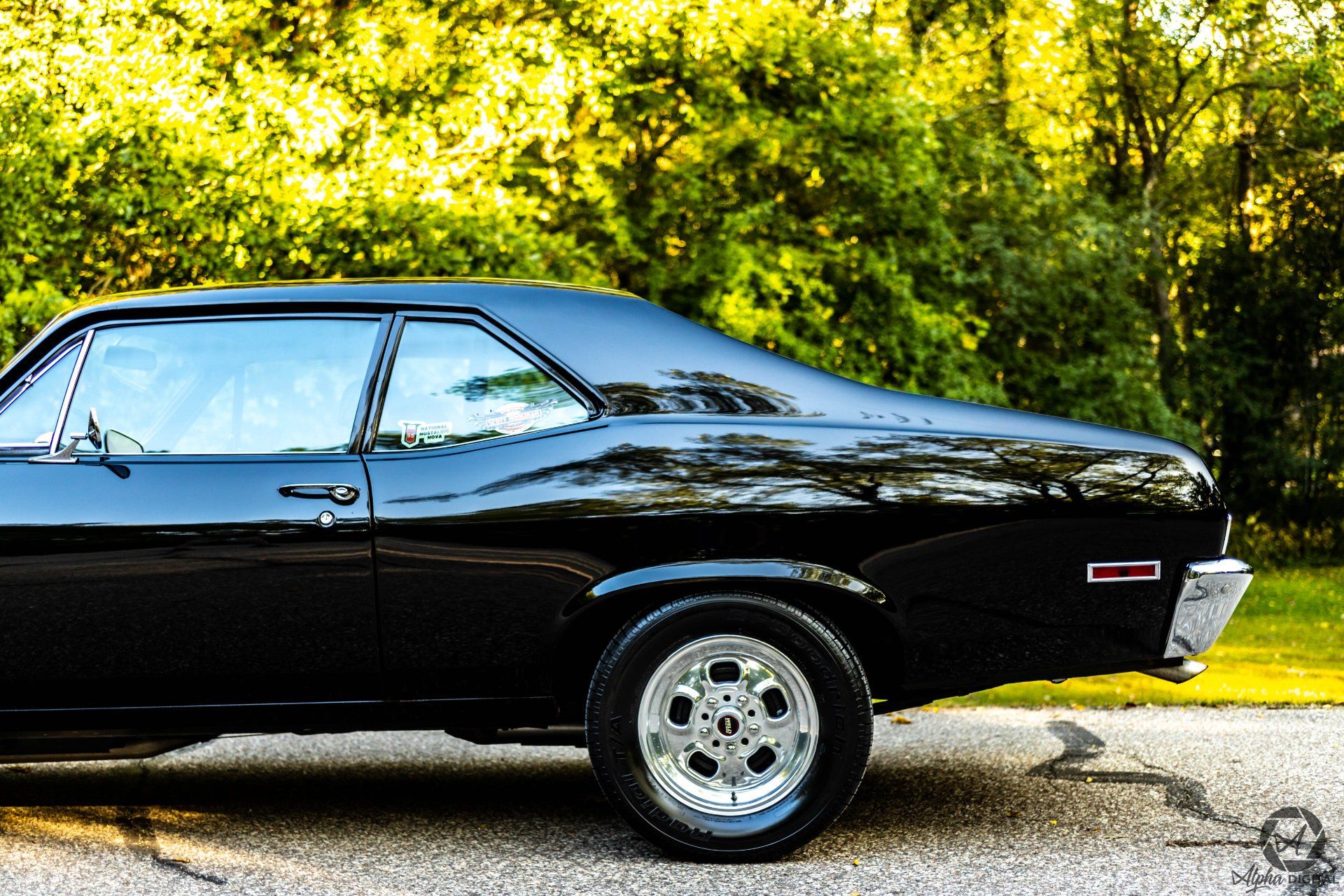A black car is parked on the side of the road.