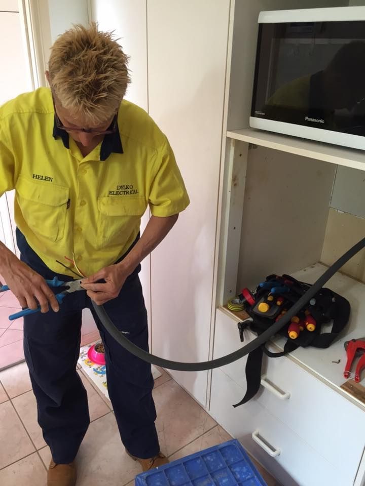 A Man in a Yellow Shirt is Working on a Electrical Line — Dylko Electrical in Wauchope, NSW