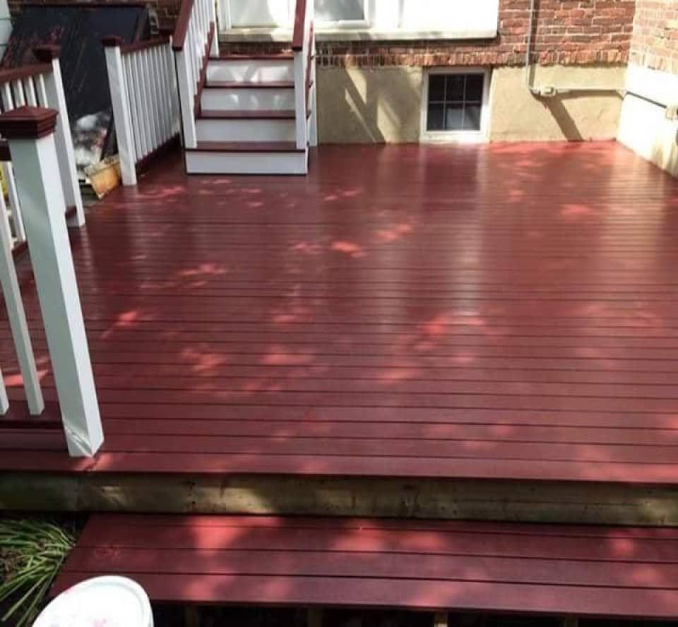 An outdoor deck painted in a natural wood finish, showcasing its rich grain pattern and warm hues.