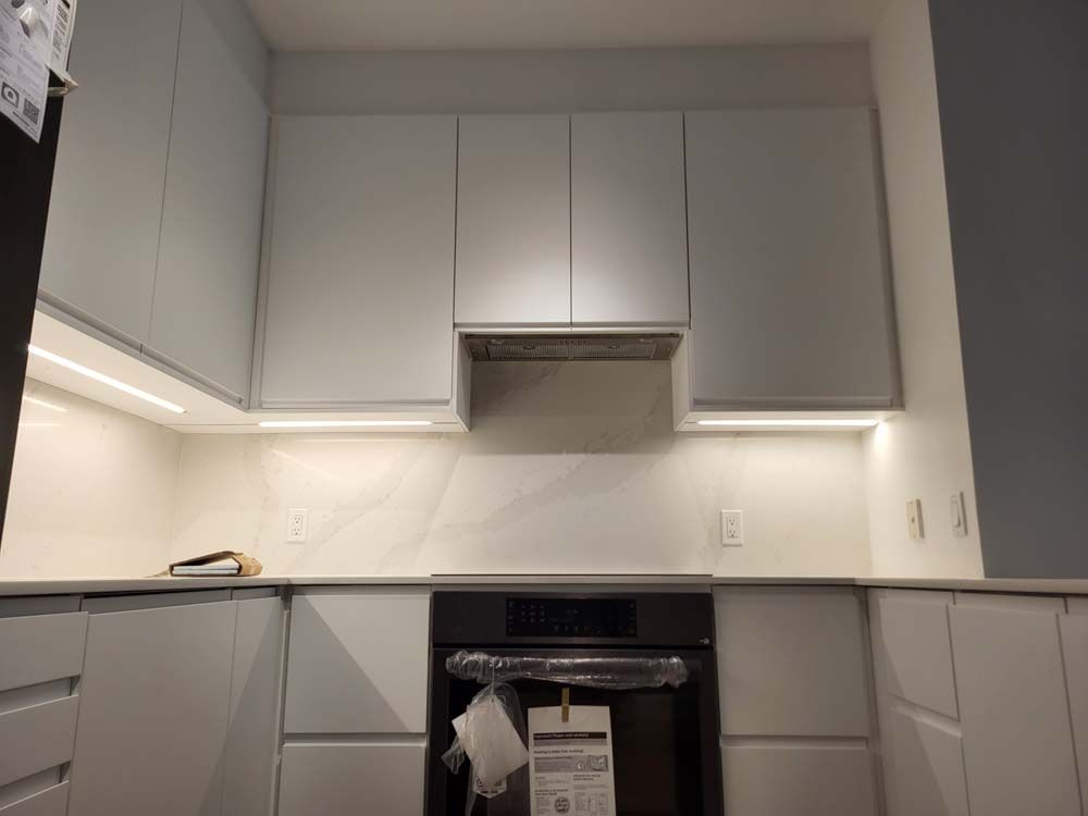 A kitchen with white cabinets and a black stove top oven.