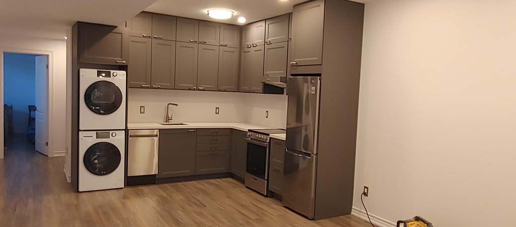 A kitchen with a washer and dryer stacked on top of each other.