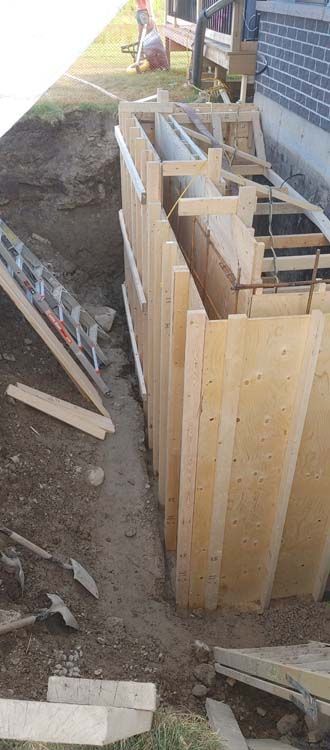 A wooden fence is being built in front of a house.