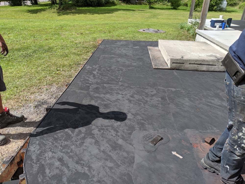 A shadow of a person is cast on a black surface.