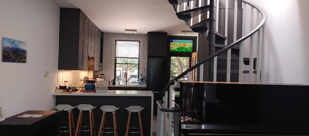 A kitchen with a spiral staircase leading to the second floor