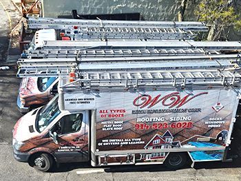 a roofing and siding truck is parked on the side of the road .