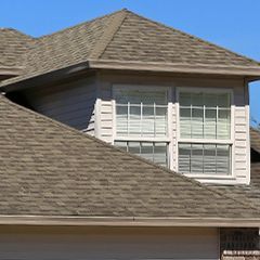 the roof of a house with two windows and shutters on it .