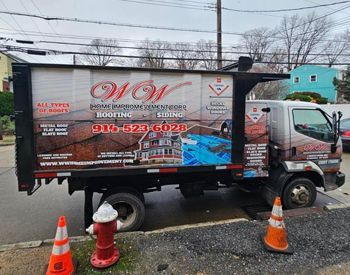 a roofing company truck is parked on the side of the road