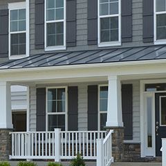 the front of a house with a porch and shutters