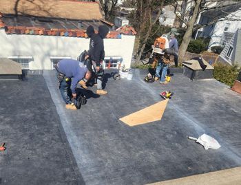 a group of men are working on a roof .