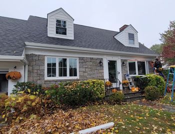 a man is working on the roof of a house .