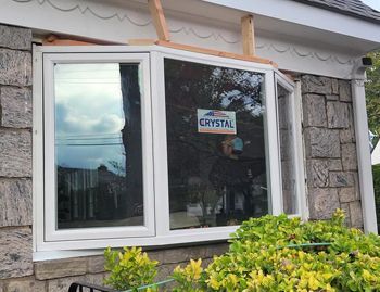 a large window is being installed on the side of a house .