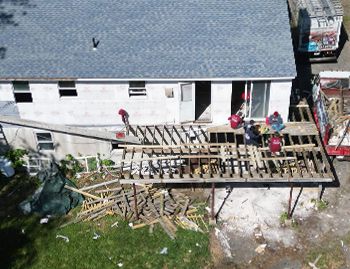 an aerial view of a house being remodeled with a deck being built .