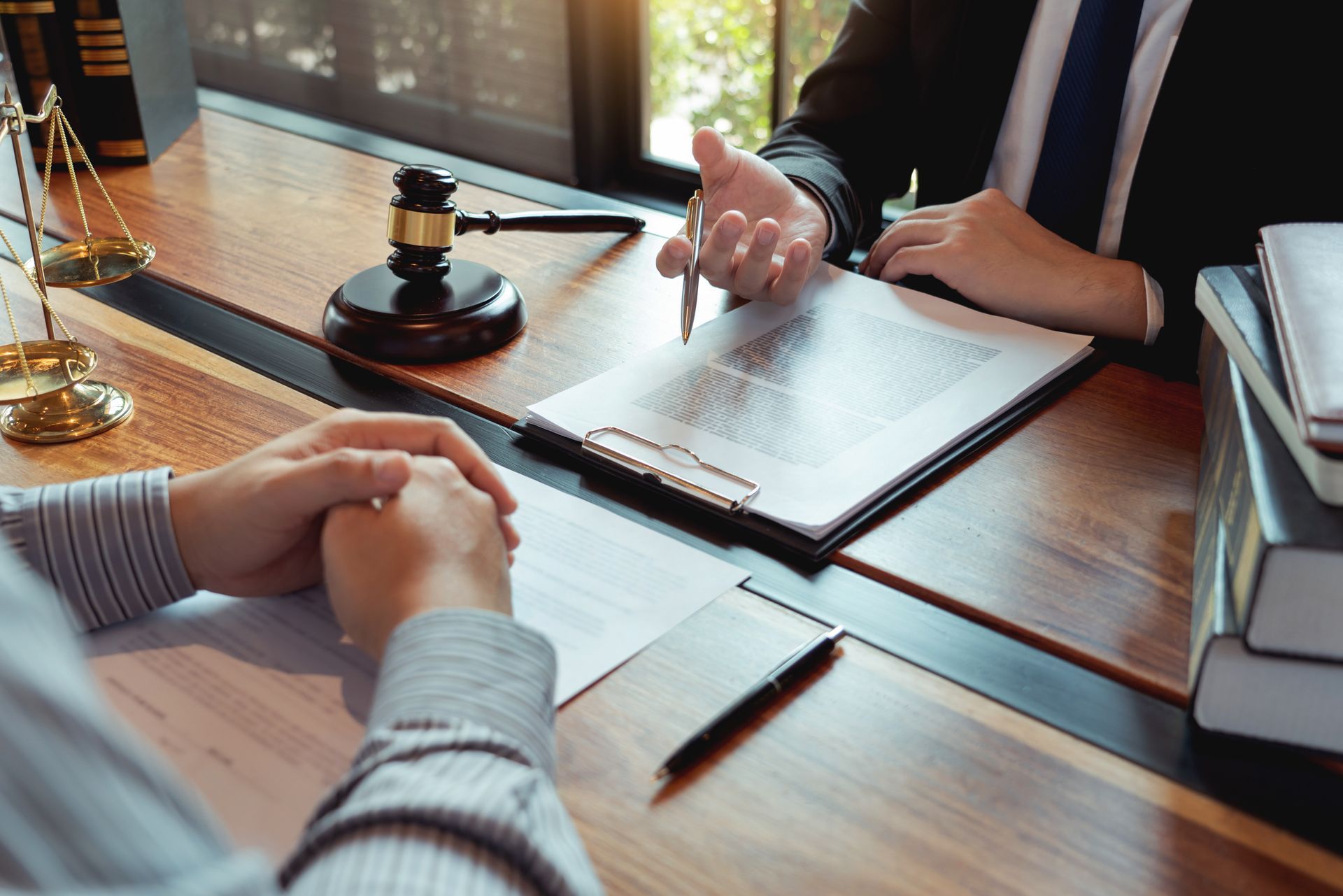 Lawyer reviewing contracts highlighting trusted attorney services beside courtroom justice scales. A family attorney in a blue suit holds a gavel on a table, with a family figure in the background.