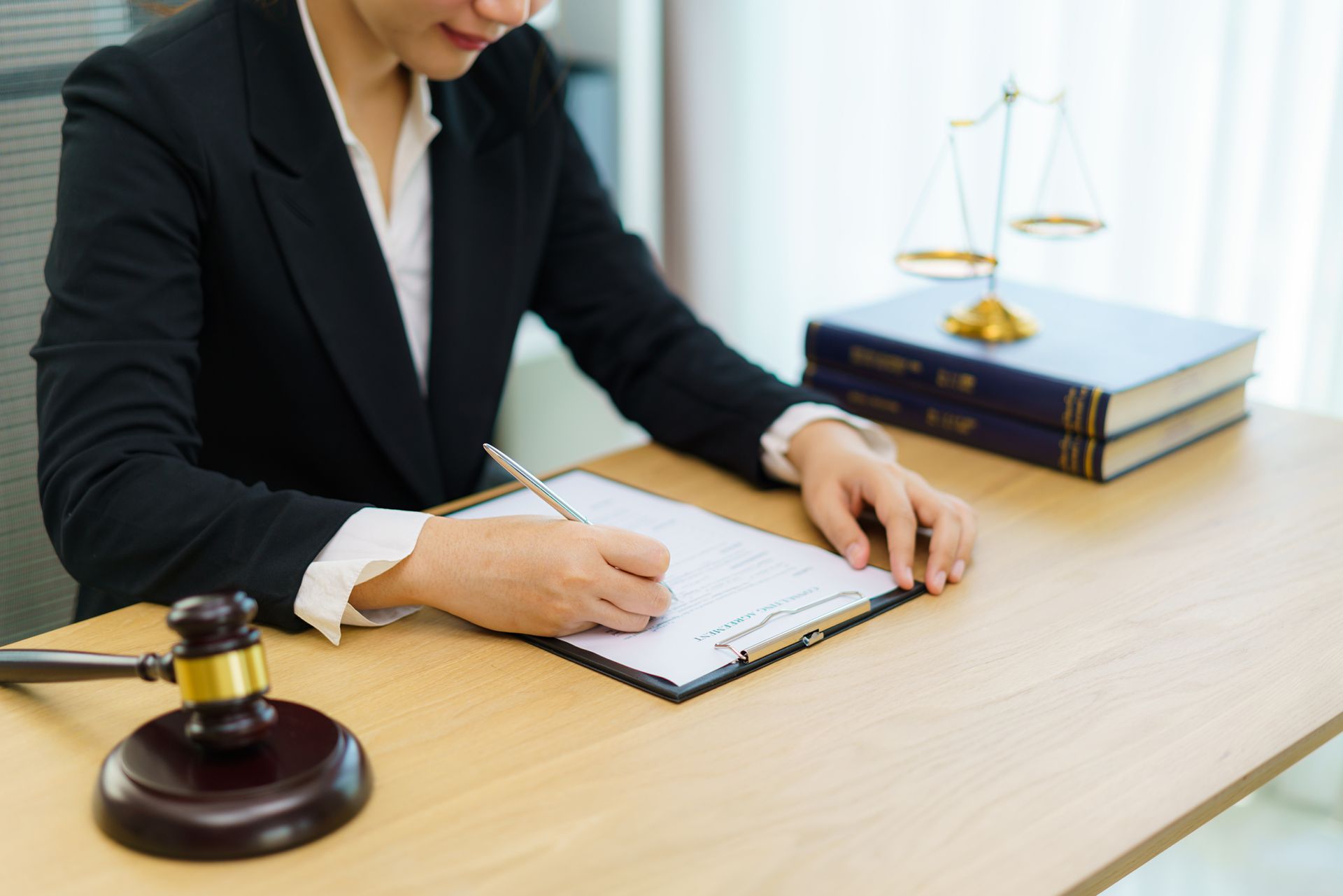 A female lawyer checking and signing documents at her office.