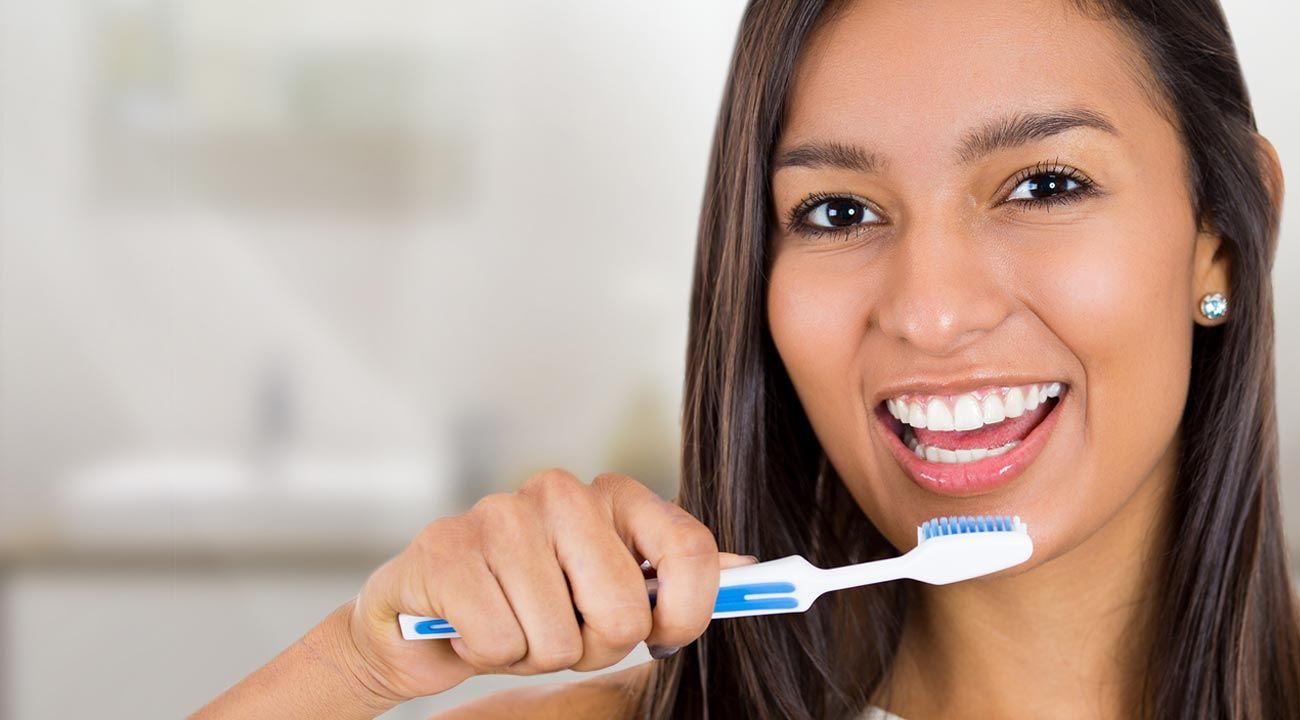 Smiling Woman Holding a Toothbrush — Lincoln, NE — Blome Family Dentistry ~ Dr Sara Wubbels, DDS