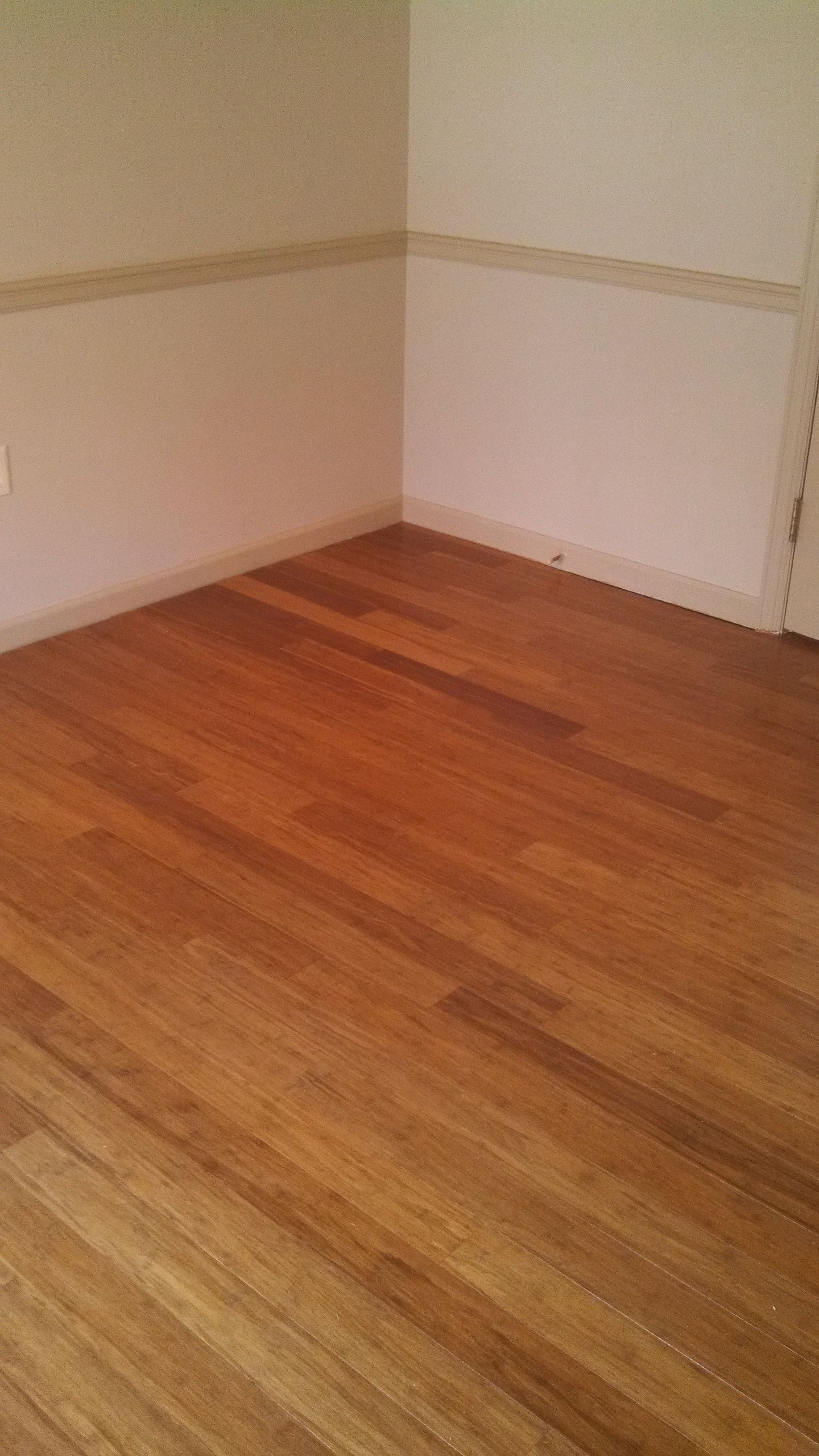 An empty room with a wooden floor and white walls.