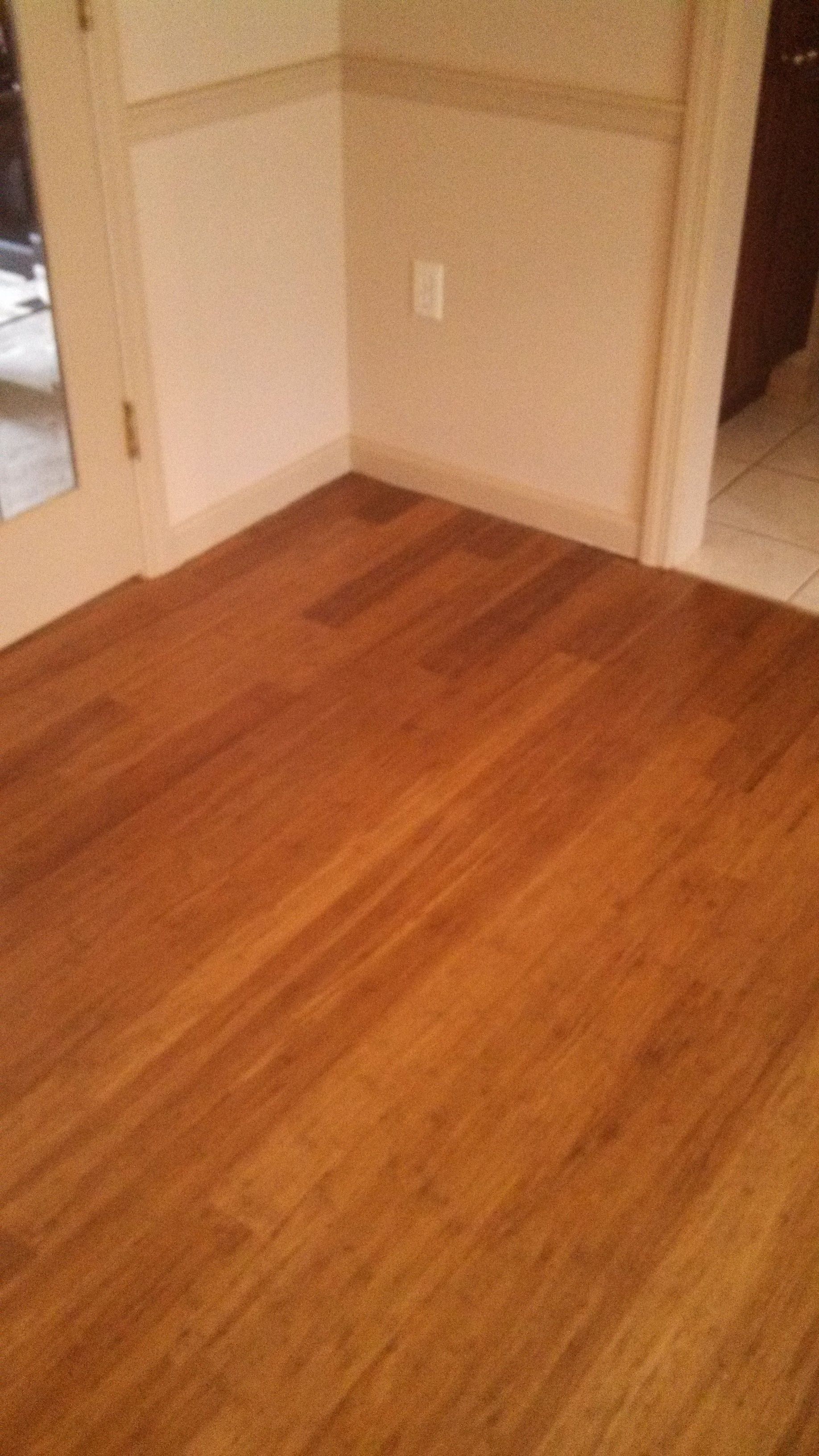 A wooden floor in a room next to a door.