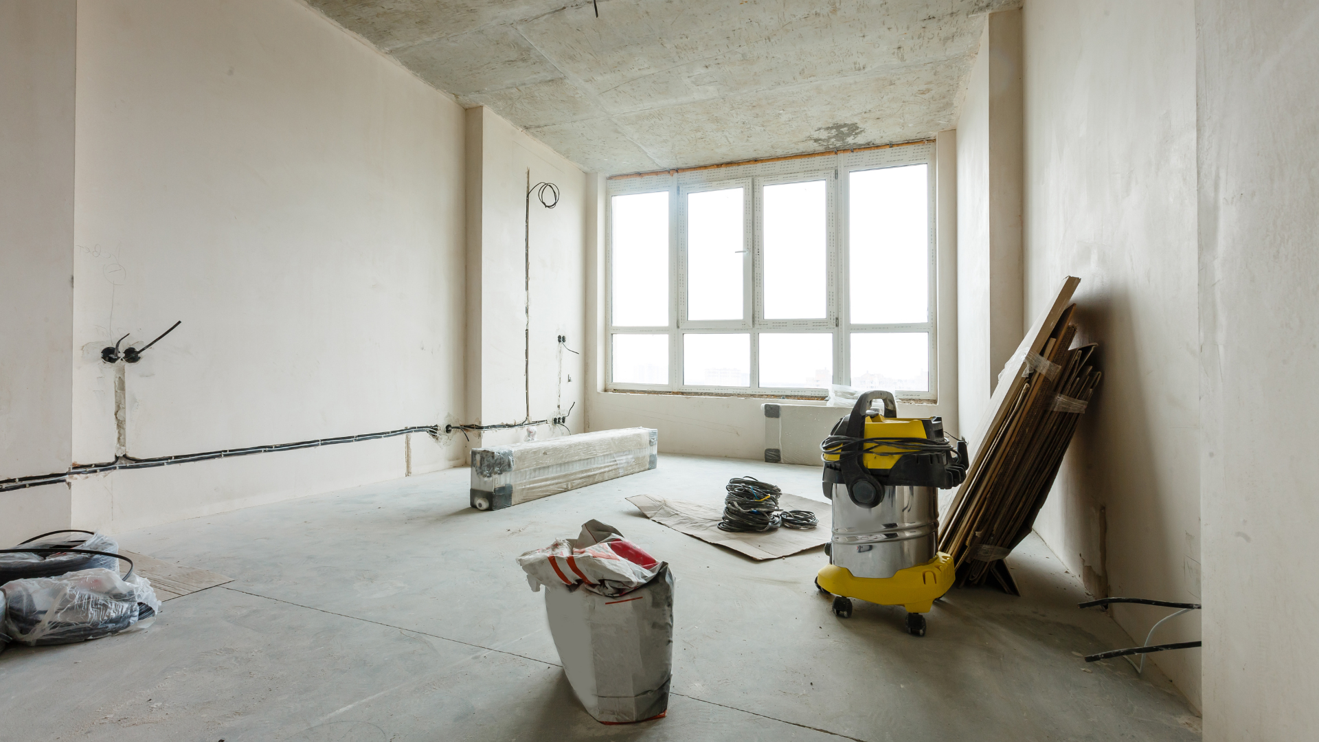 An empty basement under construction with wooden beams and stairs.