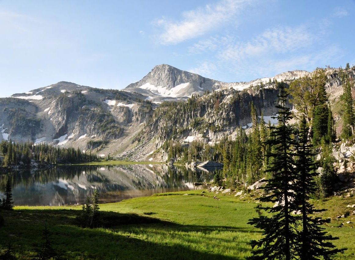 A lake in the mountains with a mountain in the background