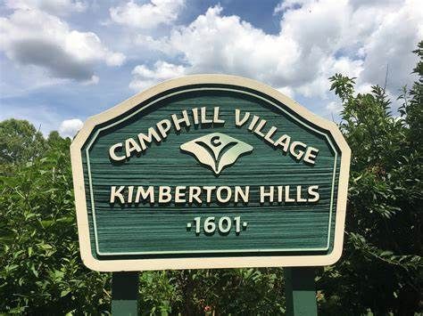 A green sign that says camphill village kimberton hills 1601