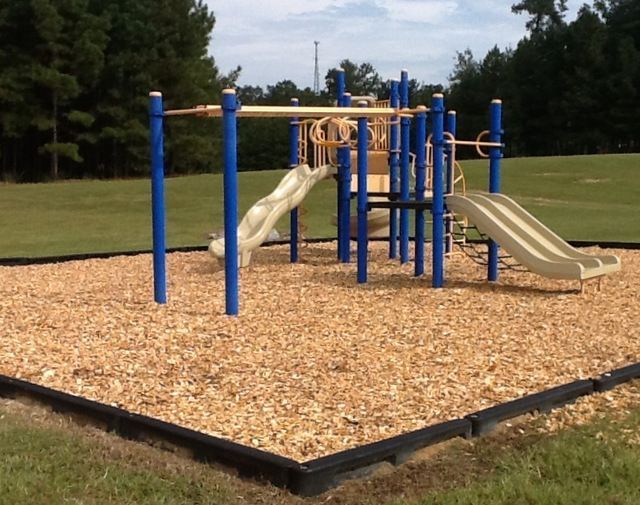 A playground with blue poles and a slide