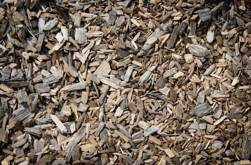 A pile of wood chips is sitting on the ground.