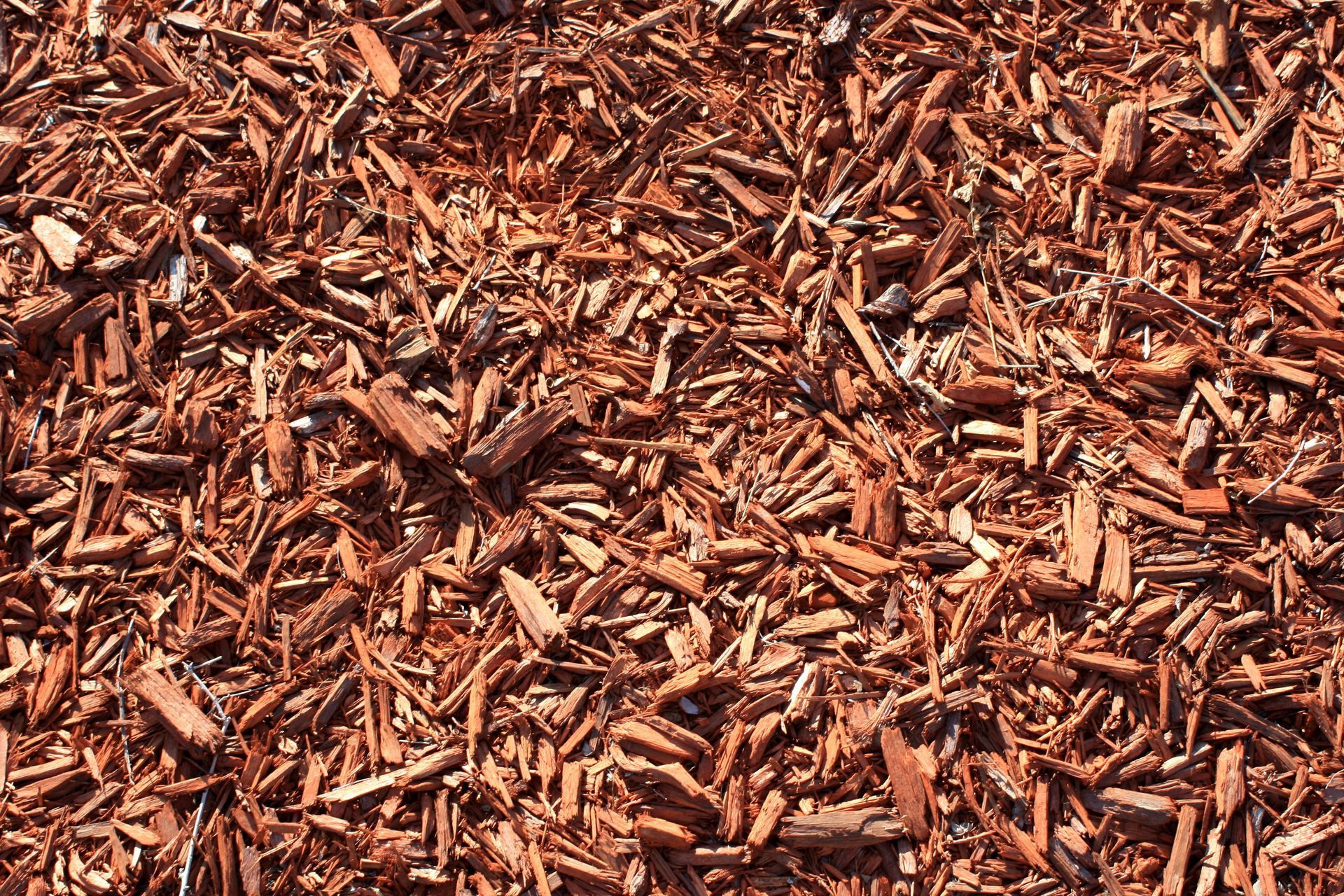 a pile of brown mulch is sitting on the ground .