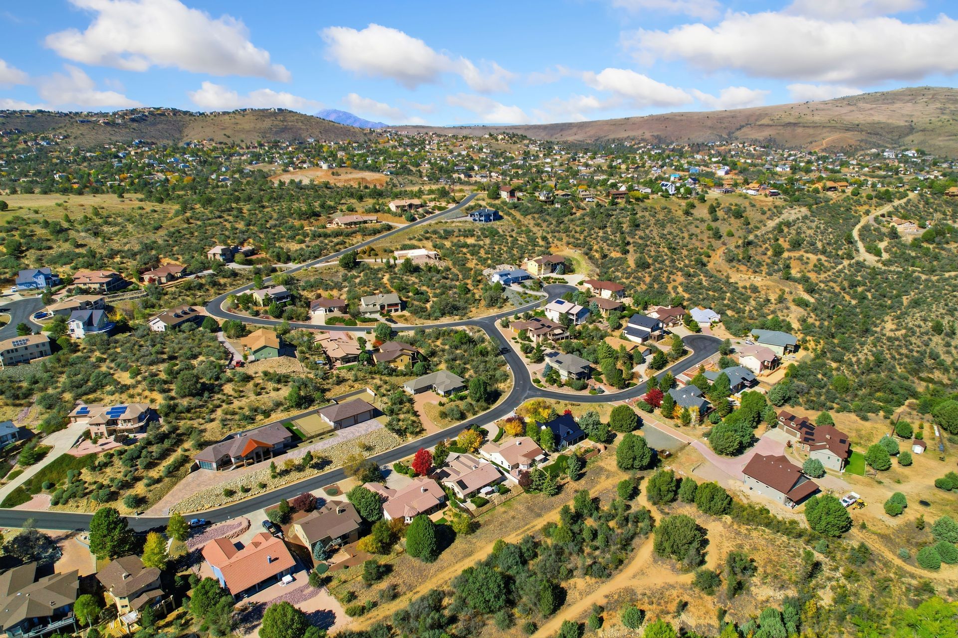 A panoramic view of a scenic hillside community and mountainous backdrop.