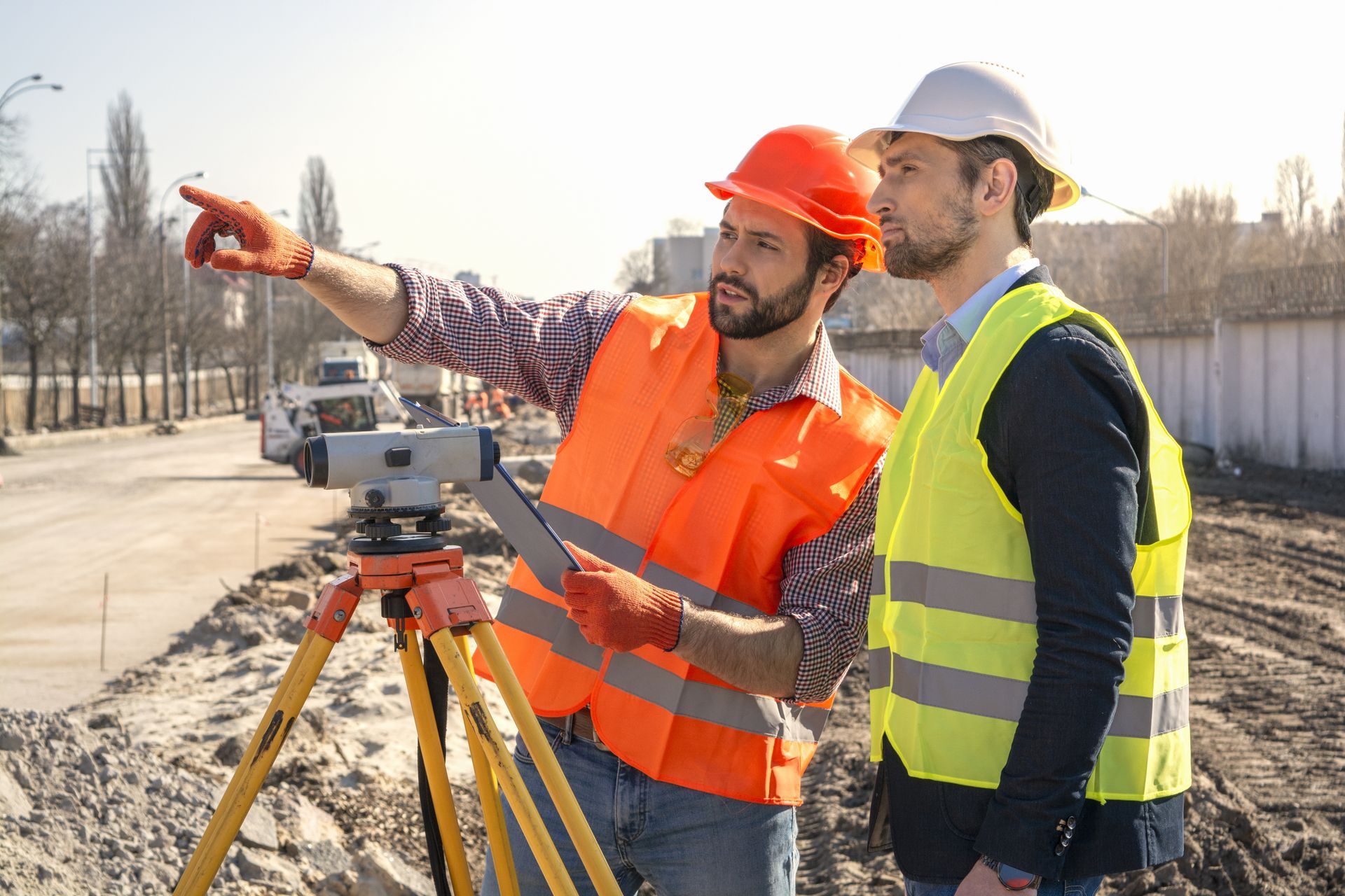 Two surveyors with a surveying device working on a construction.