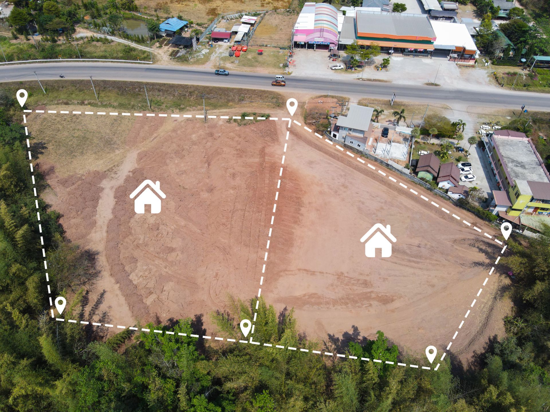 An aerial view of a vacant plot of land for two houses marked by land pins.