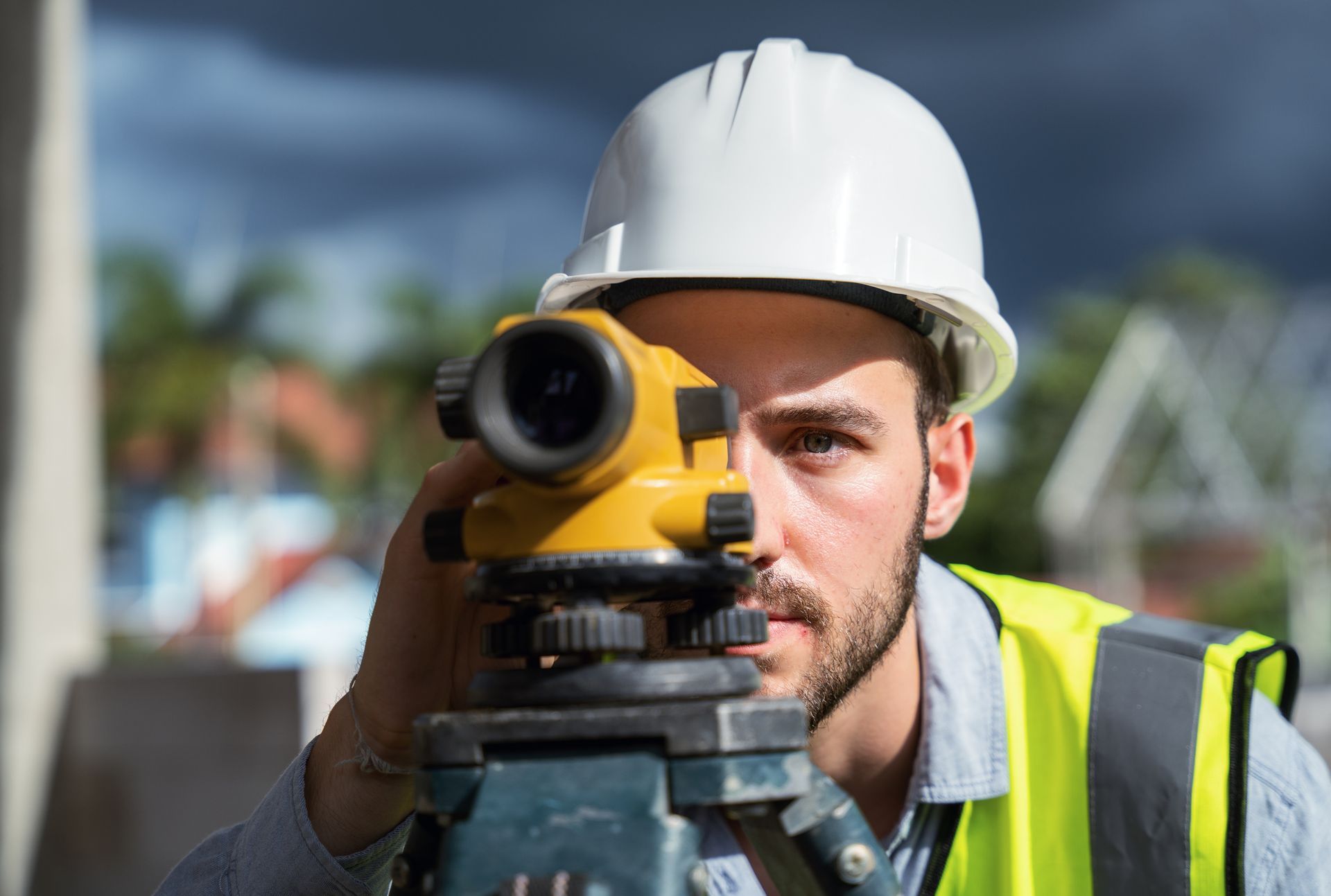 Male engineer and survey equipment working at construction site.