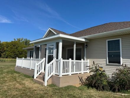 A house with a porch and a white fence