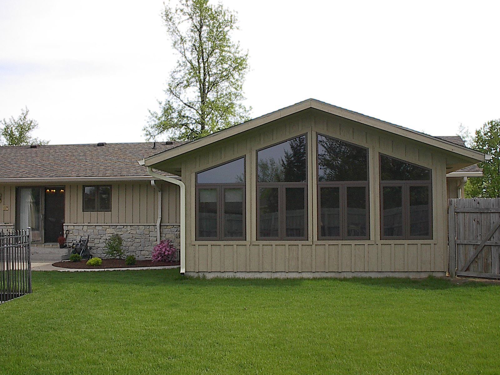 A house with a screened in porch and lots of windows