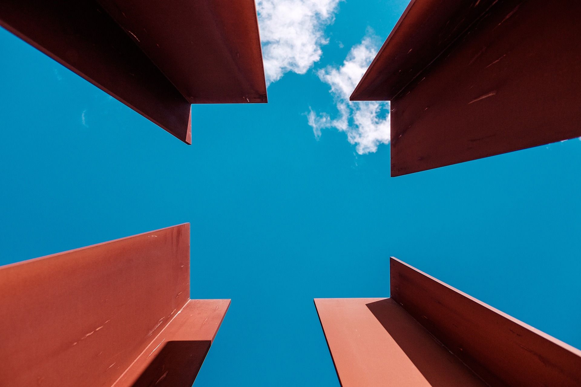 Blick nach oben auf ein Gebäude mit einem blauen Himmel im Hintergrund.
