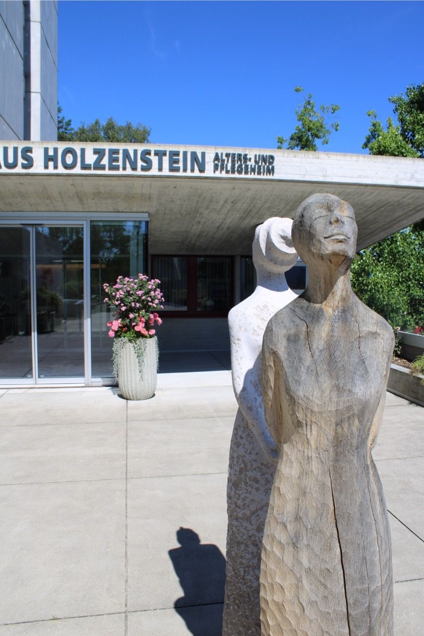 Eine Statue vor einem Gebäude mit der Aufschrift Holzenstein