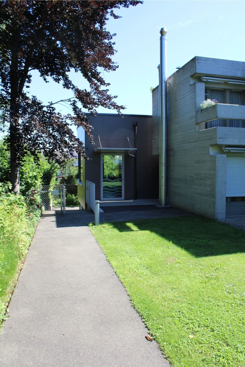 Ein Gehweg, der zu einem Haus mit einem Schornstein an der Seite führt