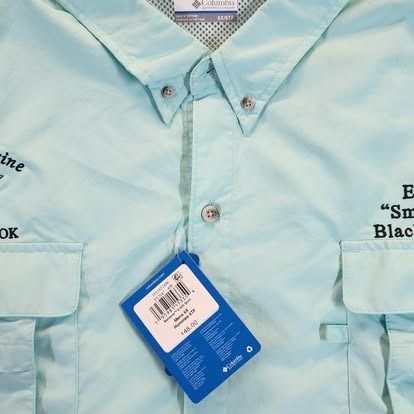A light blue columbia shirt with a tag on it
